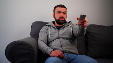 Middle-Eastern-Caucasian-Man-Sitting-On-Couch-And-Opening-Television---Close-Up