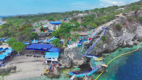 Aerial-backwards-shot-of-water-park-with-hotel-at-Saragani-Bay,-Philippines