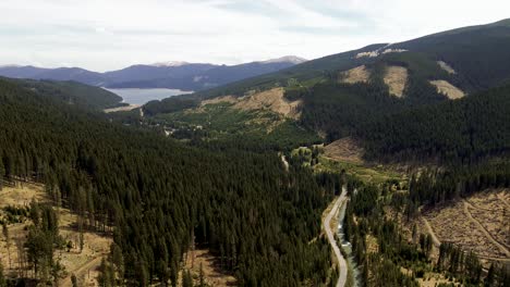 4k-cinematic-aerial-drone-stock-footage-flying-in-beautiful-mountains-in-the-Carpathians-in-Romania-with-a-small-river-and-a-big-lake-in-the-backround