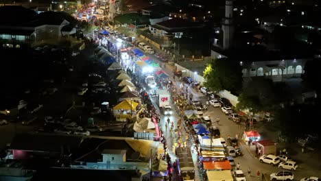 Panorama-Drohne-Senkt-Sich-Herab,-Während-Karnevalskünstler-Nachts-Die-Straße-Entlang-Marschieren