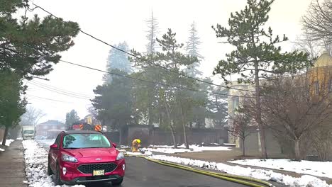 Bombero-Paleando-Tierra-Y-Nieve-A-Lo-Largo-De-Una-Carretera-Después-De-Un-Incendio-En-Una-Escuela-Abandonada-En-Montreal,-Canadá