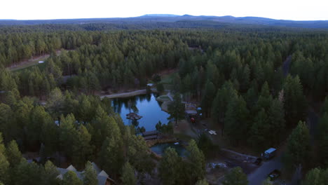 Toma-De-Drones-De-Una-Pequeña-Comunidad-Residencial-Alrededor-De-Un-Lago-En-Lo-Profundo-De-Un-Bosque-Siempre-Verde,-Arizona,-EE.UU.