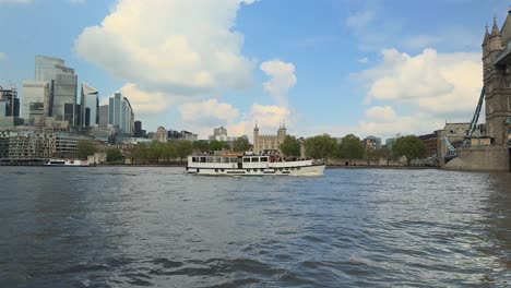 Zeitlupenaufnahme-Eines-Kleinen-Ausflugsboots-Auf-Der-Themse,-Das-Am-Tower-Von-London-Vorbeifährt-Und-Dann-Unter-Der-Tower-Bridge-Hindurchfährt