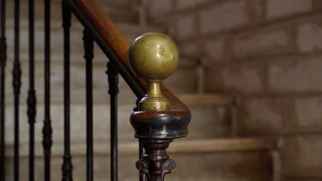 Slow-orbiting-shot-around-a-brass-ball-handrail-on-a-staircase-in-a-villa
