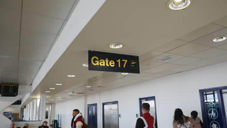 Terminal-17-Del-Aeropuerto,-Puerta-Diecisiete,-Cartel-En-Una-Concurrida-Sala-De-Espera-De-Embarque
