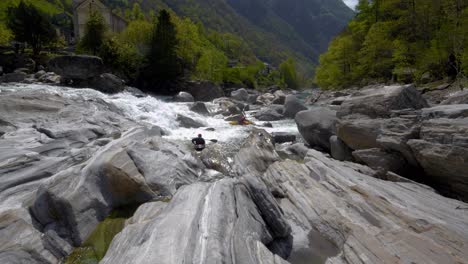 In-Der-Nähe-Eines-Wasserfalls,-Kajakfahrer-Im-Wilden-Bach-In-Der-Nähe-Von-Lavertezzo,-Verzascatal-Zwischen-Großen-Steinen
