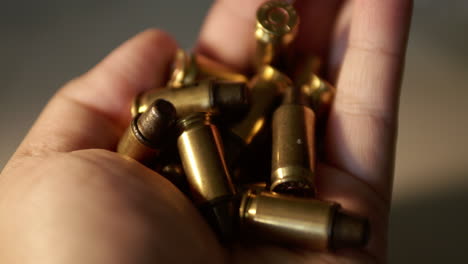 Close-up-of-a-fistful-of-empty-bullet-shell-casings-being-held-in-one-hand