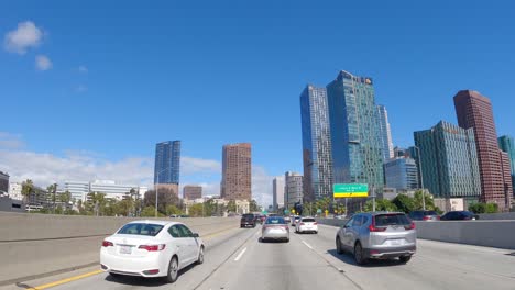 Sunny-Los-Angeles-highway-drive-with-cars-and-skyline,-daytime