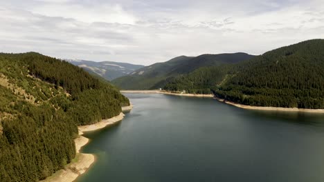 4k-cinematic-aerial-drone-stock-footage-flying-over-a-beautiful-dam-in-Romanian's-Carpathians-in-a-location-called-Voineasa-lake