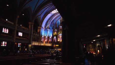 Shot-of-the-central-nave-and-the-aisle-with-parishioners-in-the-Notre-Dame-Cathedral-of-Montreal,-Canada