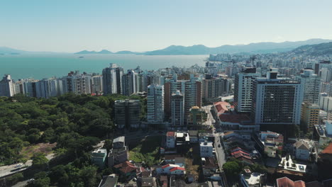 Discover-the-marvelous-downtown-of-Florianopolis,-with-its-myriad-buildings-set-against-the-backdrop-of-the-stunning-green-sea