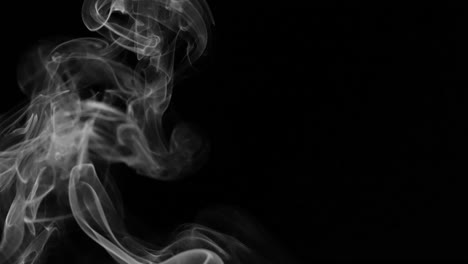Eine-Rauchspur-Mit-Einzigartigen-Formen-Und-Wirbeln-Isoliert-Auf-Einem-Schwarzen-Hintergrund