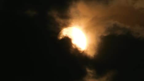 Telephoto-view-of-the-sun-with-dramatic-dark-storm-clouds,-horror-feeling