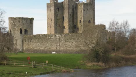 Río-Que-Fluye-Suavemente-Frente-Al-Histórico-Castillo-De-Trim-En-Trim-Town,-Condado-De-Meath,-Irlanda,-Un-Entorno-Sereno