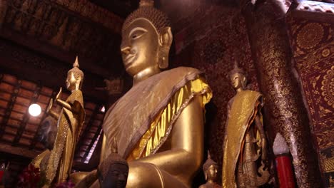 tall-golden-statue-of-buddha-inside-temple-in-Luang-Prabang,-Laos-traveling-Southeast-Asia