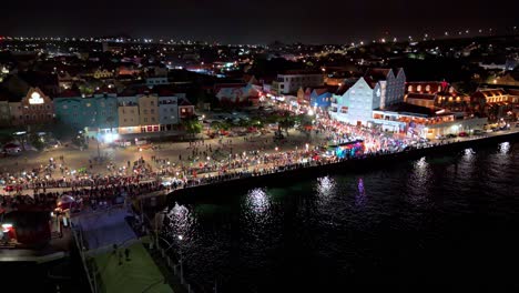 Panoramic-aerial-orbit-of-Gran-Marcha-passing-Queen-Emma-pontoon-bridge-at-night