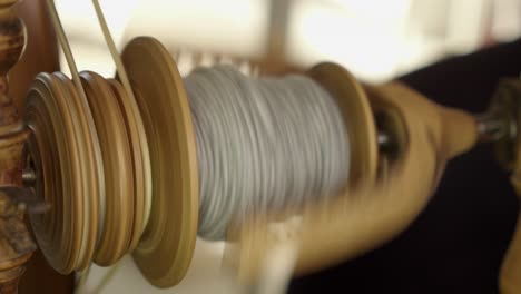 Closeup:-Bobbin-of-grey-wool-yarn-spins-on-vintage-spinning-wheel