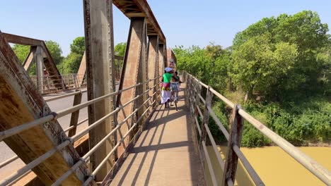Los-Negros-Locales-Cruzando-Un-Puente-En-El-Norte-De-Ghana-Llevando-Bicicletas