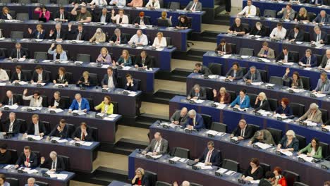 Panning-shot-of-European-Parliament-politicians-voting-during-EU-plenary-session-in-Strasbourg,-France---Medium-shot