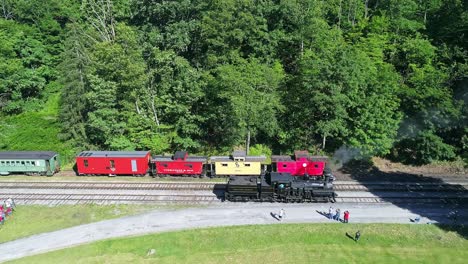 Luftaufnahme-Einer-Antiken-Dampflokomotive,-Die-An-Einem-Sonnigen-Sommermorgen-Langsam-Rückwärts-Fährt,-Um-Sich-Einem-Bahnhof-Zu-Nähern