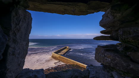 Lapso-De-Tiempo-Del-Muelle-De-Bloques-De-Concreto-Visto-Desde-Arriba-A-Través-De-Una-Ventana-De-Castillo-De-Piedra-Medieval-En-Un-Día-Soleado-Y-Nublado-Ubicado-En-El-Condado-De-Easkey-En-Sligo-A-Lo-Largo-Del-Camino-Atlántico-Salvaje-En-Irlanda