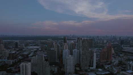 El-Anochecer-Se-Posa-Sobre-El-Paisaje-Urbano-De-Bangkok,-Mezclando-Modernos-Rascacielos-Con-Edificios-Tradicionales-Bajo-Un-Cielo-Color-Pastel.