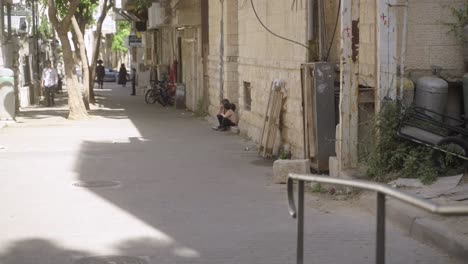 Streets-of-Jerusalem,-Jerusalem,-Israel,-people-walking,-kids-sitting-on-doorsteps