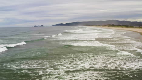 Las-Olas-Del-Océano-Rompen-Rompiendo-Y-Dejando-Un-Rastro-De-Espuma-Blanca-Detrás-En-El-Agua,-Costa-De-Oregon