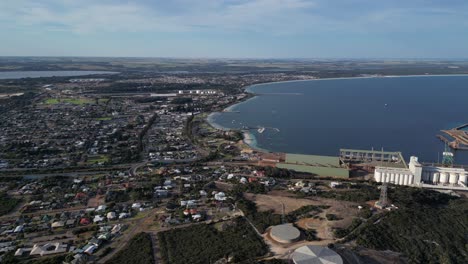 Aerial-wide-shot-of-Esperance-City-with-Ocean-and-grain-factory-beside-port-at-sunset