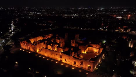Aerial-Pullback-Reveals-Baths-of-Caracalla-at-Night-in-Historic-Rome,-Italy