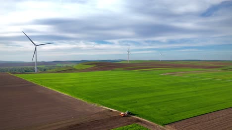 Windkraftanlagen-Und-Traktor-Arbeiten-An-Land-Bei-Sonnenuntergang-Im-Rostigen-Iasi-Rumänien