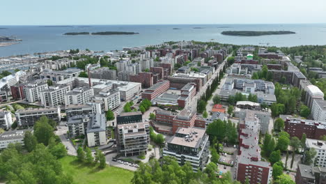 Panoramic-drone-shot-overlooking-the-cityscape-of-Lauttasaari,-summer-in-Helsinki