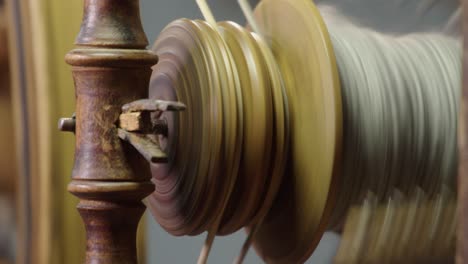 Full-frame-bobbin-closeup:-antique-spinning-wheel-spins-wool-into-yarn