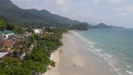 Aerial-Flying-Over-Along-White-Sand-Beach-At-Koh-Chang-With-Tourists-Enjoying-The-Day