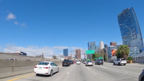 Busy-Los-Angeles-freeway-under-clear-blue-skies,-timelapse-of-cars-in-motion