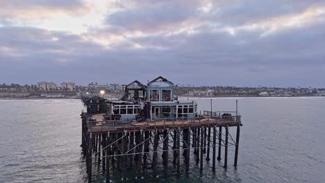 Muelle-De-Oceanside-California-Dañado-Por-El-Fuego-Antiguo-Restaurante-Rubys-Diner-Dron-Cuarto-De-Círculo-Paralelo-De-Oeste-A-Norte