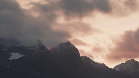 Gewitterwolken-Im-Gegenlicht-Der-Untergehenden-Sonne-Ziehen-über-Die-Schneebedeckten-Berggipfel