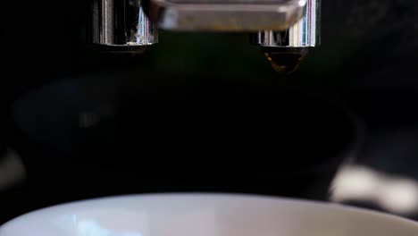 Close-up-of-Italian-Coffee-machine-with-hot-water-and-steaming-black-coffee