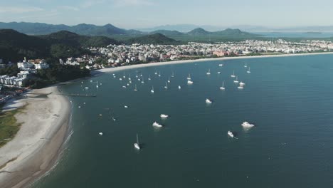 Luftaufnahme-Von-Booten,-Die-An-Einem-Wunderschönen-Sonnigen-Morgen-Vor-Dem-Atemberaubenden-Strand-Von-Jurere-In-Florianopolis-Vor-Anker-Liegen