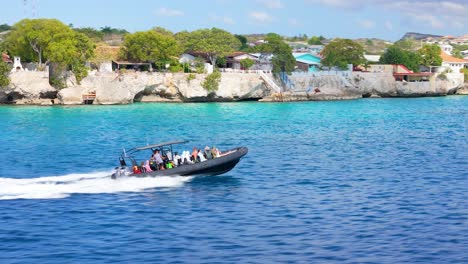 Aerial-orbit-around-dive-tour-boat-in-Curacao-driving-out-to-reef-snorkel-site