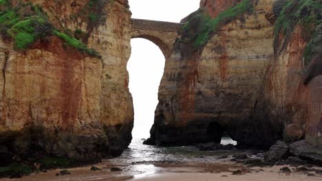 The-Roman-Bridge-Arch-From-Praia-Dos-Estudantes-In-Lagos,-Algarve,-Portugal