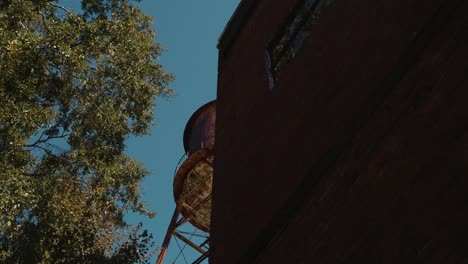 Revealing-from-Behind-Large-Building-and-Old-Rusty-Water-Tower