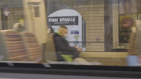 Paris,-Frankreich---31.-Dezember-2020:-Ein-Zug-Verlässt-Den-Bahnhof-Und-Enthüllt-Das-Schild-„Bonne-Nouvelle“,-Was-„Gute-Nachricht“-Bedeutet,-Auf-Der-Rückseite-Der-U-Bahn-Station.