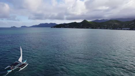 Imágenes-De-Drones-Pasando-Una-Canoa-De-Vela-En-Las-Claras-Aguas-Verdes-Y-Azules-Del-Océano-Pacífico-Cerca-De-La-Isla-De-Oahu-En-Las-Islas-Hawaianas.