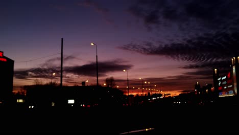 Static-view-of-evening-traffic-driving-along-the-Jorga-Zemitana-bridge-in-Riga,-Latvia-at-sunset-with-a-beautiful,-colorful-sky