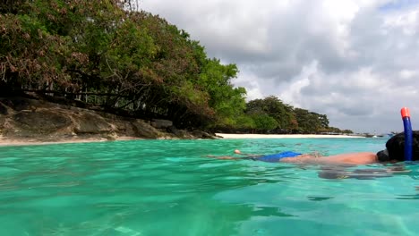 Un-Hombre-Disfruta-Buceando-En-Aguas-Azules-Cerca-De-La-Costa