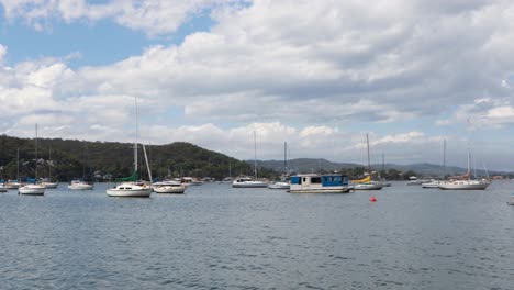 panning-past-boats-in-the-harbor-lake-with-beautiful-view-of-mountains