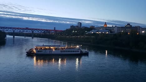 Edmonton-River-Boat-Company-En-El-Río-North-Saskatchewan-Dando-Un-Giro-Inverso-Frente-Al-Puente-De-Bajo-Nivel-Mientras-Los-Pasajeros-Cenan-Bailando-Por-La-Noche-Mientras-El-Barco-Atraca-Y-Regresa-Al-Puerto.