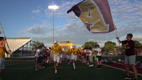 Football-players-running-out-of-an-inflatable-tunnel-before-a-Friday-Night-game-on-a-Fall-evening