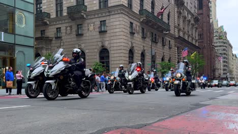 A-low-angle-shot-of-a-parade-of-motorcycle-police-officers-from-different-states,-riding-down-Fifth-Avenue-on-a-cloudy-day-in-New-York